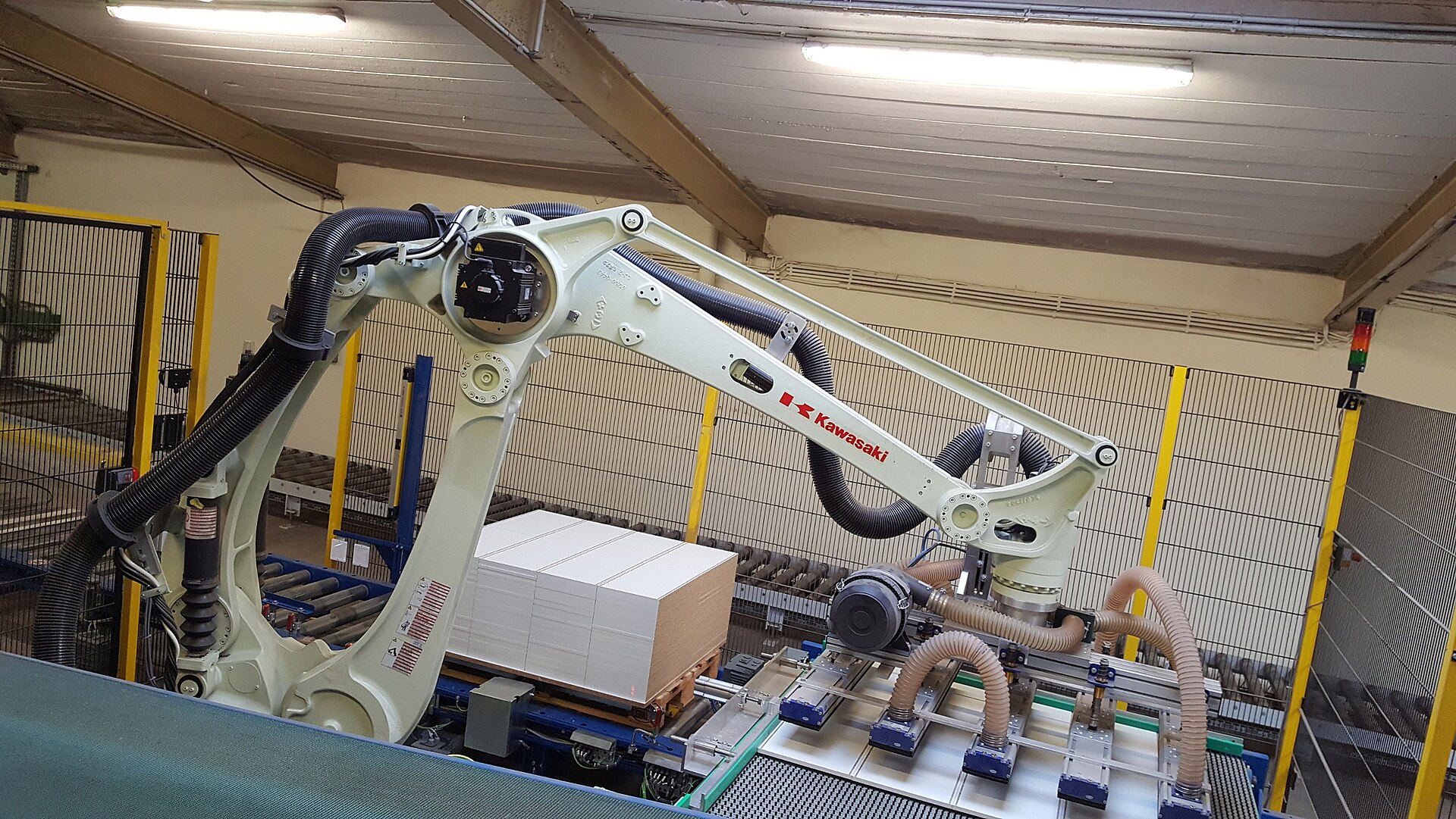 A Kawasaki palletizing robot installed at a German manufacturing facility for handling furniture parts, illustrating the type of Kawasaki industrial automation equipment deployed in production environments.